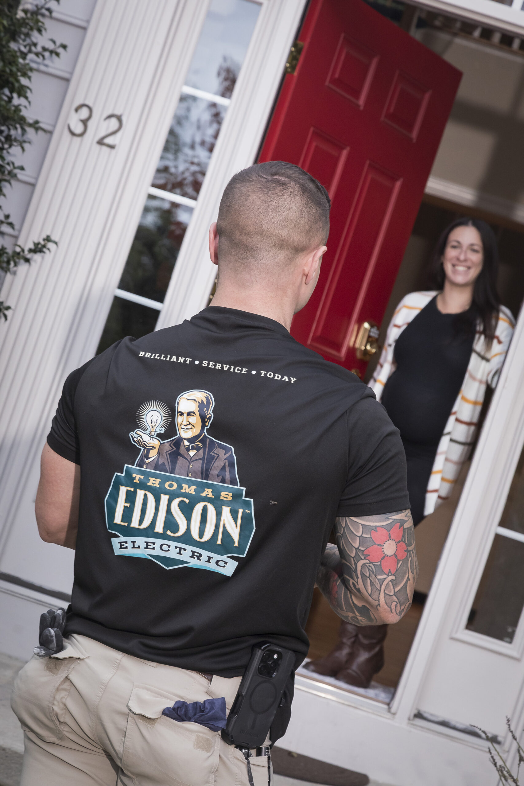 Electrician greeting a homeowner at the door for a scheduled service visit.