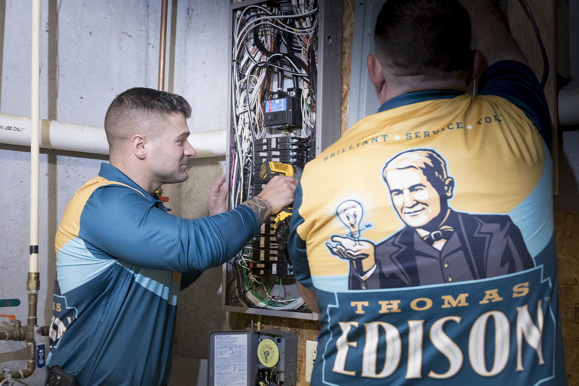 Electricians servicing a residential electrical panel together.
