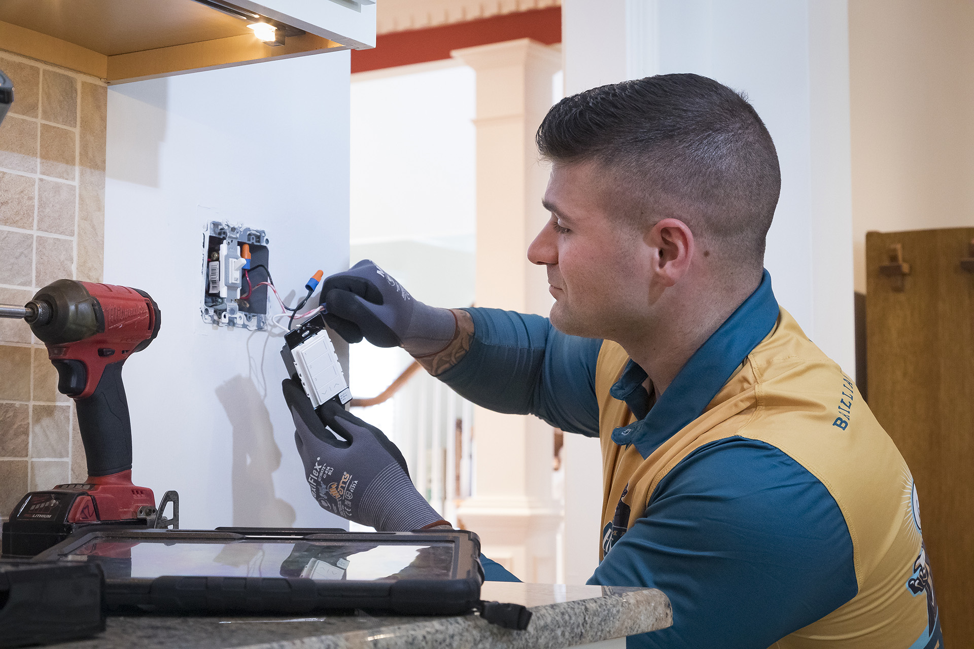 Electrician installing a modern light switch in a residential kitchen.