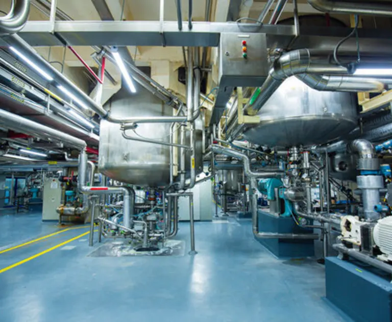 The image depicts a high-tech industrial processing facility, commonly used in chemical blending or food manufacturing.