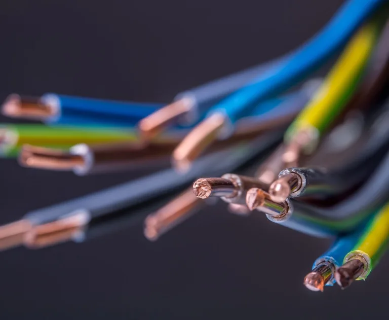 This image shows a close-up of insulated electrical cables. Cables are made of multiple insulated wires grouped together to carry electrical current safely. The colorful insulation allows for identification of different wire functions within a circuit, such as live or neutral wires.