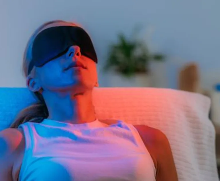 A woman undergoing colored light therapy.