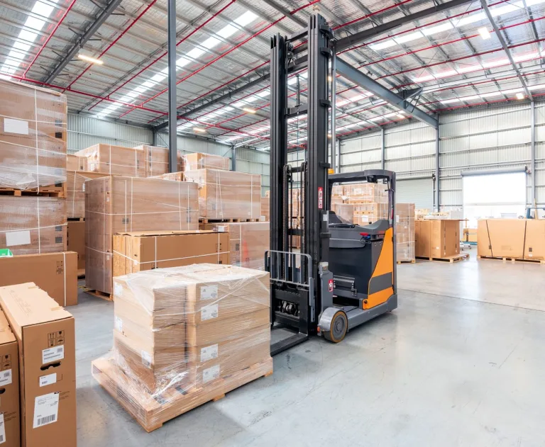 This image features a warehouse order picker, which is a type of material handling equipment designed for picking items from high storage racks.