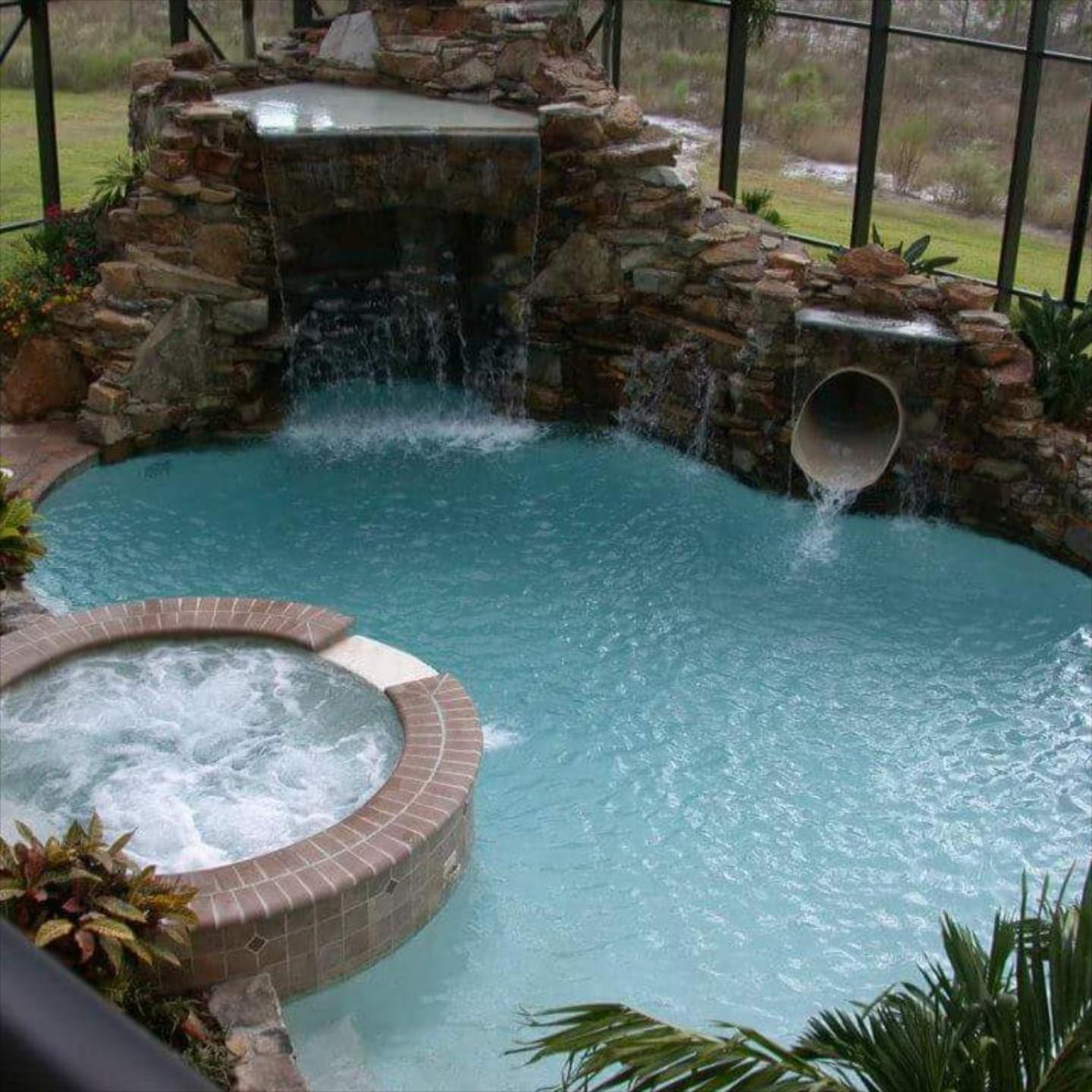 This image features a custom luxury swimming pool and hot tub installation.