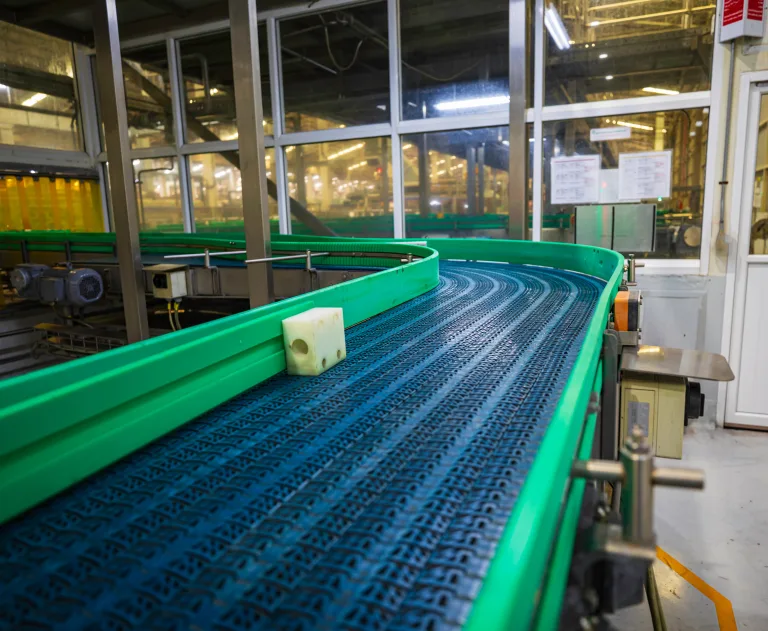 This image shows an industrial conveyor system, likely utilized in a manufacturing or bottling plant.