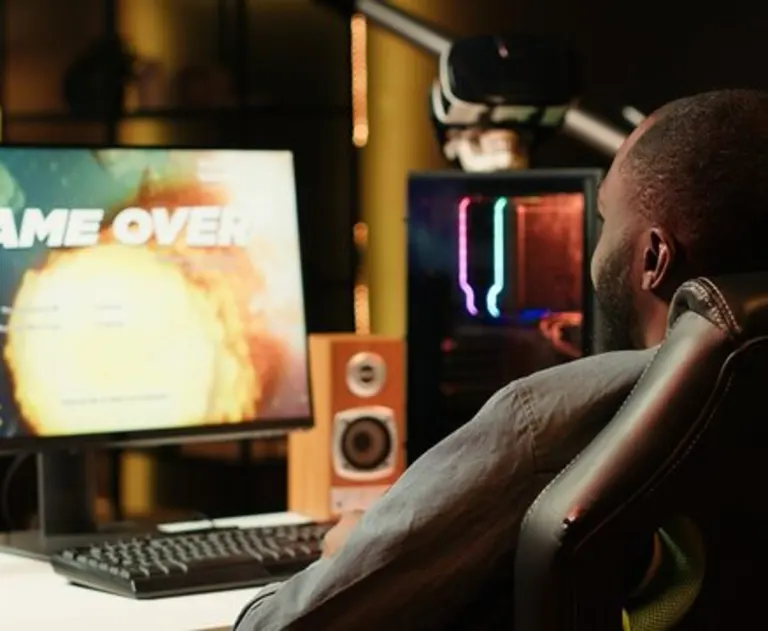 This image shows a gamer playing a science fiction spaceship shooting game, specifically one where they are shooting meteorites or enemies. The game is currently at a "Game Over" screen following an explosion.