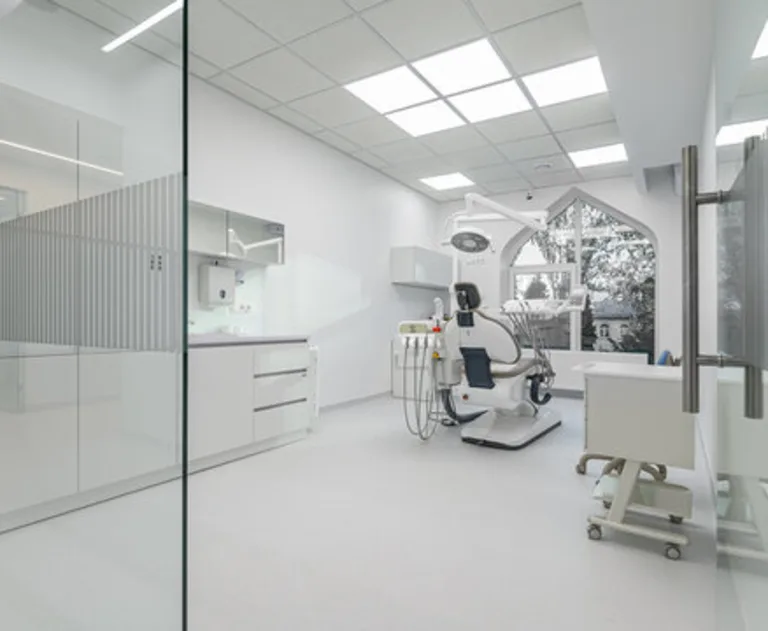 The image shows the interior of a modern dental treatment room designed with a focus on hygiene and minimalism.