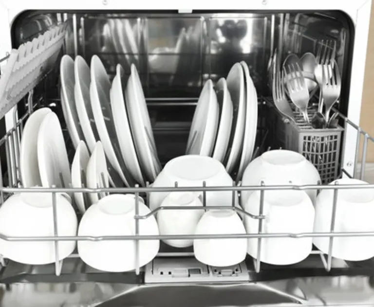 A dishwasher loaded with plates, bowls, and silverware.