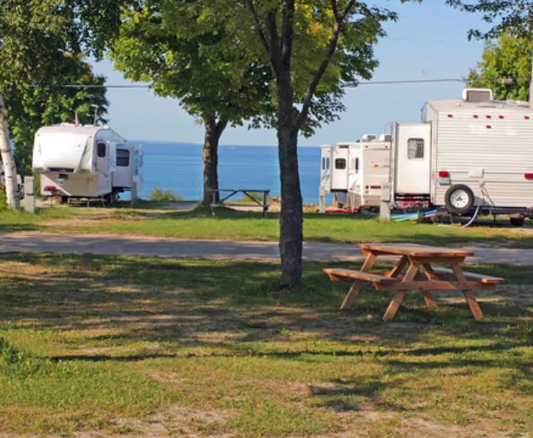 This image shows a scenic RV park or campground located directly along a lakeshore.