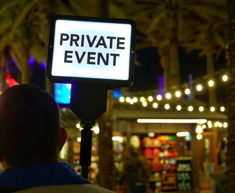 The image displays a glowing sign indicating a restricted gathering. The text PRIVATE EVENT is prominently featured on a backlit sign.