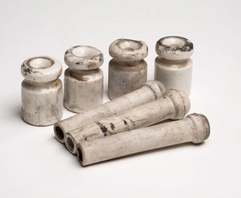 These items are antique ceramic insulators used in "knob and tube" wiring systems from the early 20th century.