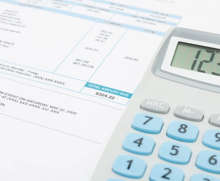This image displays a financial document alongside a calculator, commonly used for managing personal finances, budgeting, or calculating household expenses.