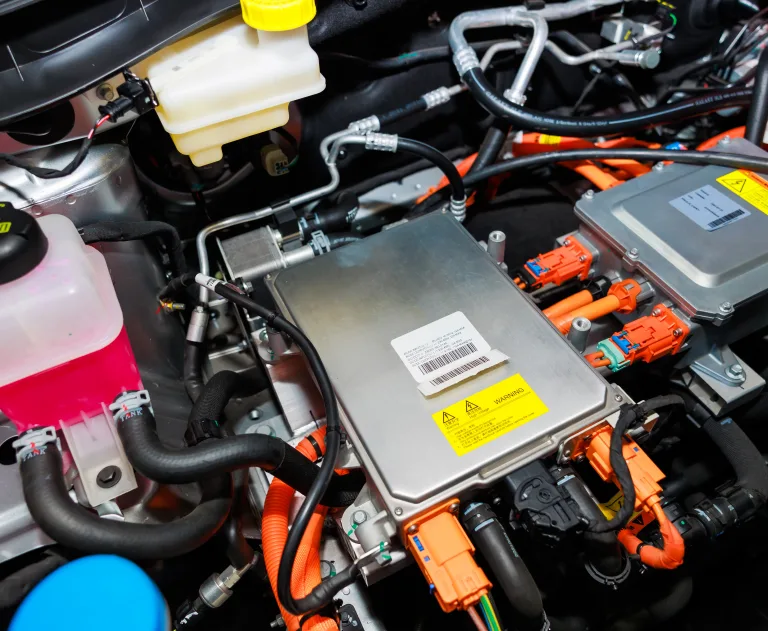 This image shows a high-voltage components compartment of an electric vehicle, featuring an inverter or power management unit.