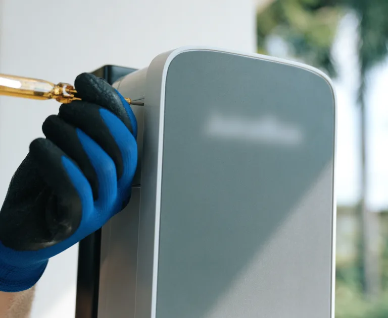 The item pictured is a home electric vehicle (EV) charging station. This is likely a Level 2 charger, which operates on a 240V circuit and is significantly faster than a standard Level 1 outlet.