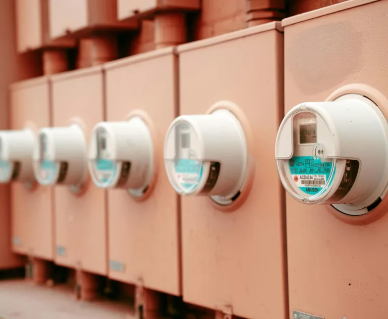The image displays a series of electrical smart meters, which are devices used by utility companies to measure and communicate energy consumption data in real-time.