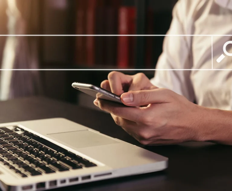 This image shows someone searching on their phone and laptop for an electrician near me.