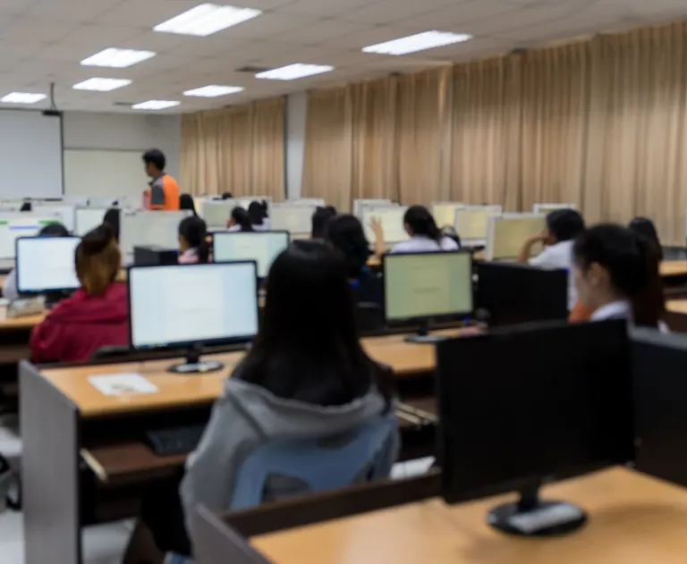 This image shows a classroom setting where individuals are engaged in a computer-based activity.