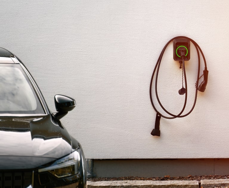 AdobeStock_663678264 - Thomas Edison Electric The image displays a modern electric vehicle home charging setup.