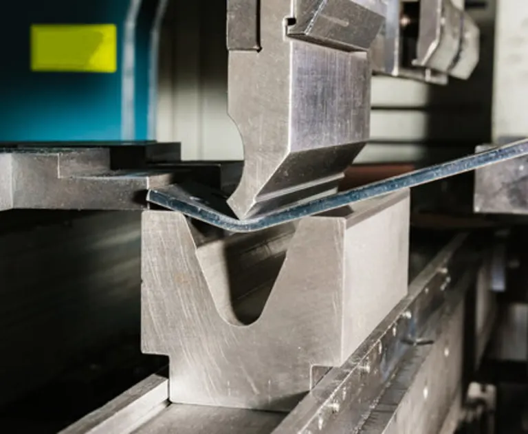 working_with_sheet_metal_on_CNC_hydraulic_press_brake - Thomas Edison Electric This image shows a hydraulic press brake machine bending a piece of sheet metal.