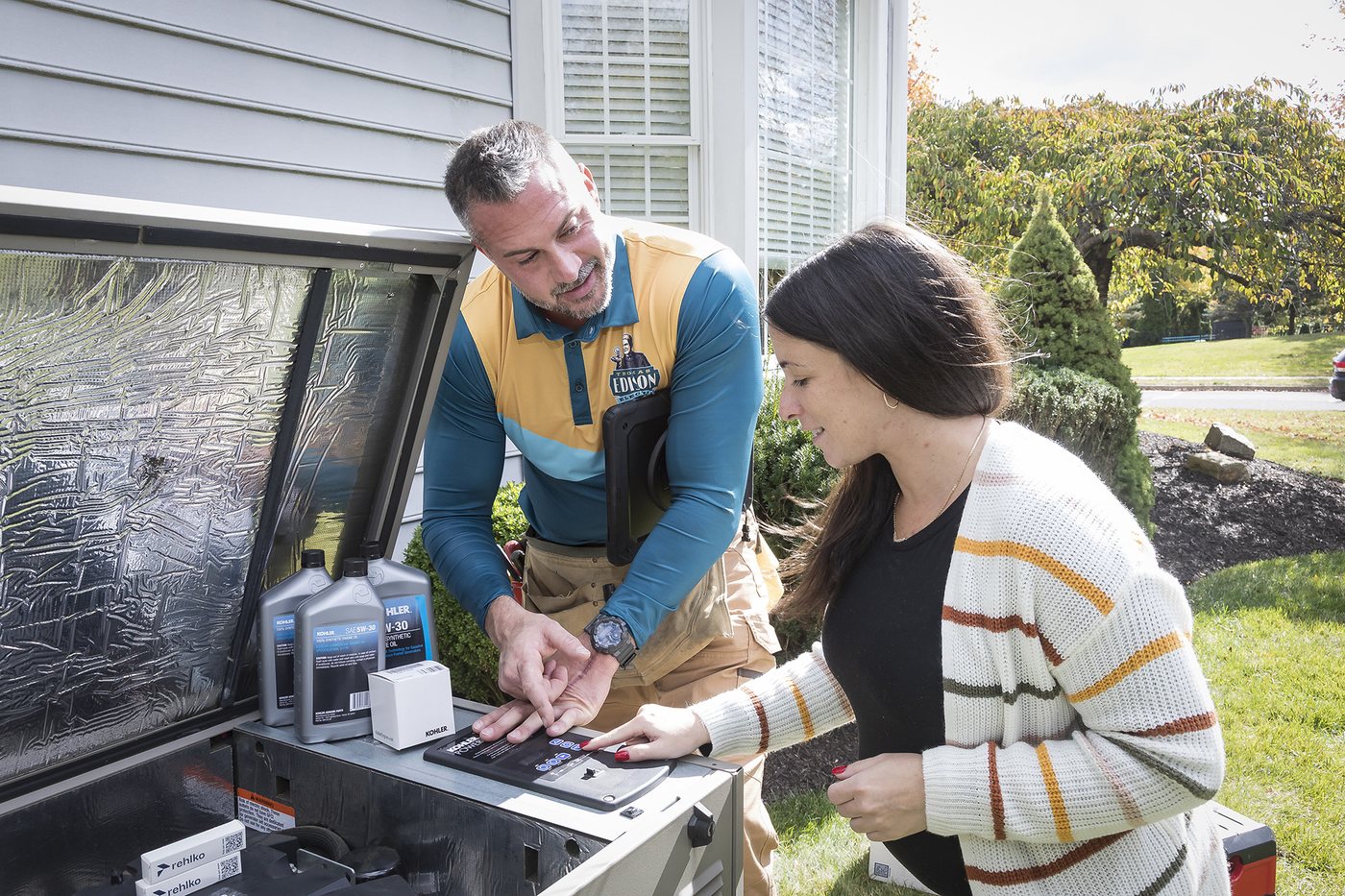 A Thomas Edison Electric electrician walking a homeowner through a standby generator