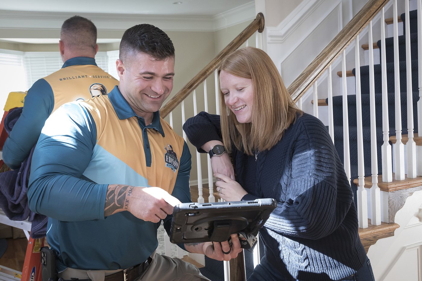 A Thomas Edison Electric electrician reviewing service options with a homeowner